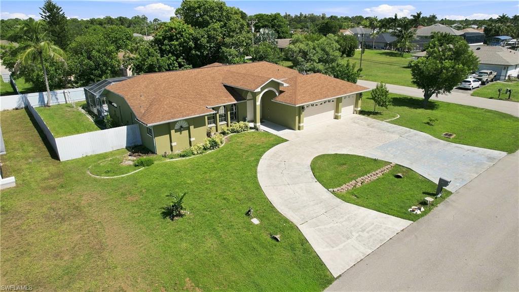 Single-story residence with an attached two-car garage, a curved concrete driveway, and a screened enclosure