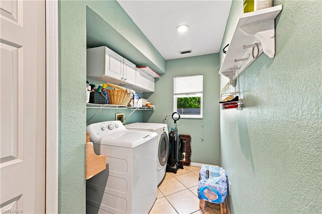 Laundry area featuring tile flooring, a window with blind, recessed lighting, and wall-mounted shelving