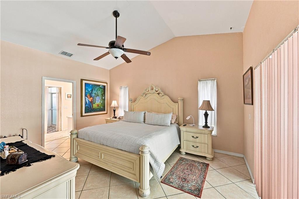 Vaulted ceiling with a ceiling fan, light-toned tiled flooring, and vertical blinds