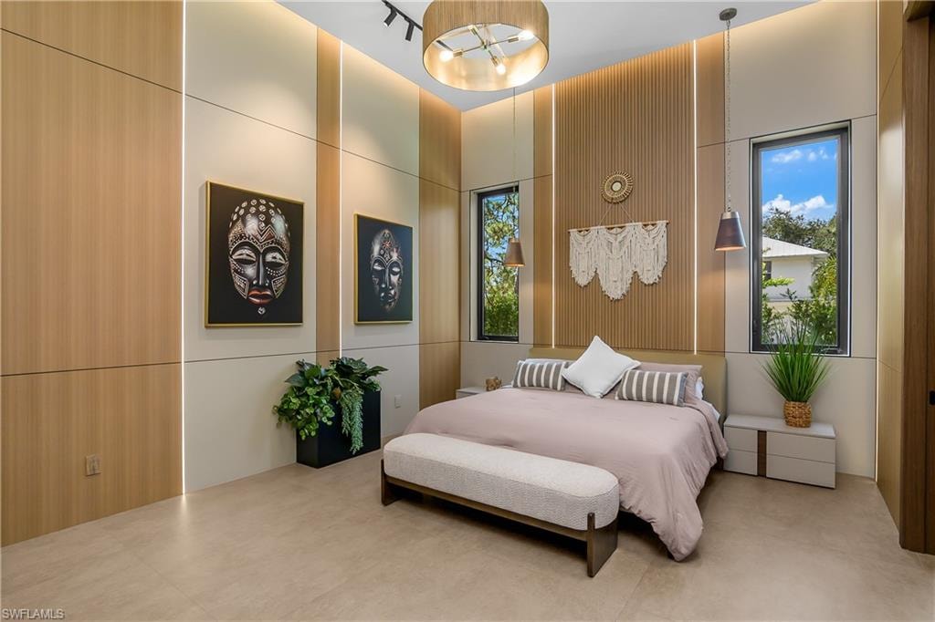 Integrated wall paneling with accent lighting, light-toned flooring, two recessed windows, and a ceiling-mounted light fixture