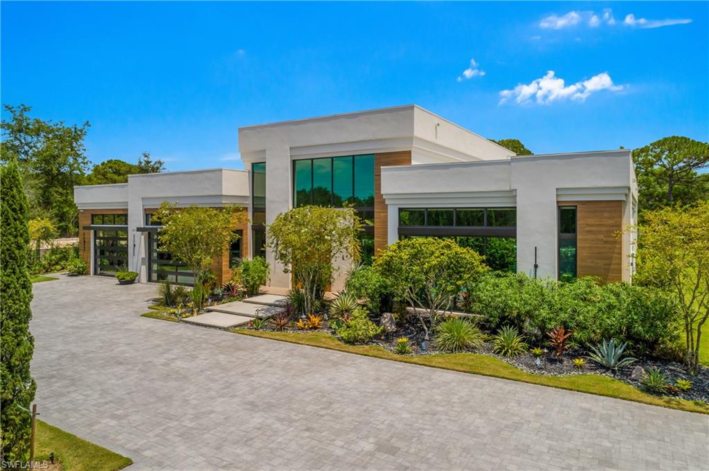 Modern architectural design featuring expansive glass windows, smooth white stucco, and wood-finish siding