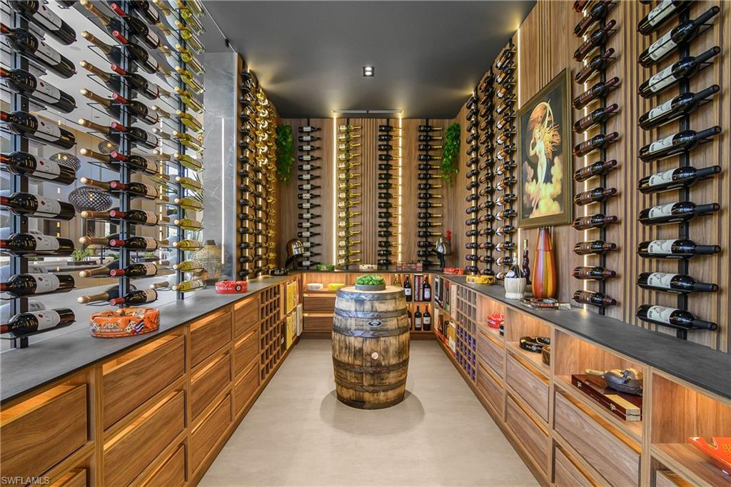 Custom wine cellar featuring extensive bottle storage, wood-finish paneling, under-cabinet lighting, and a neutral flooring