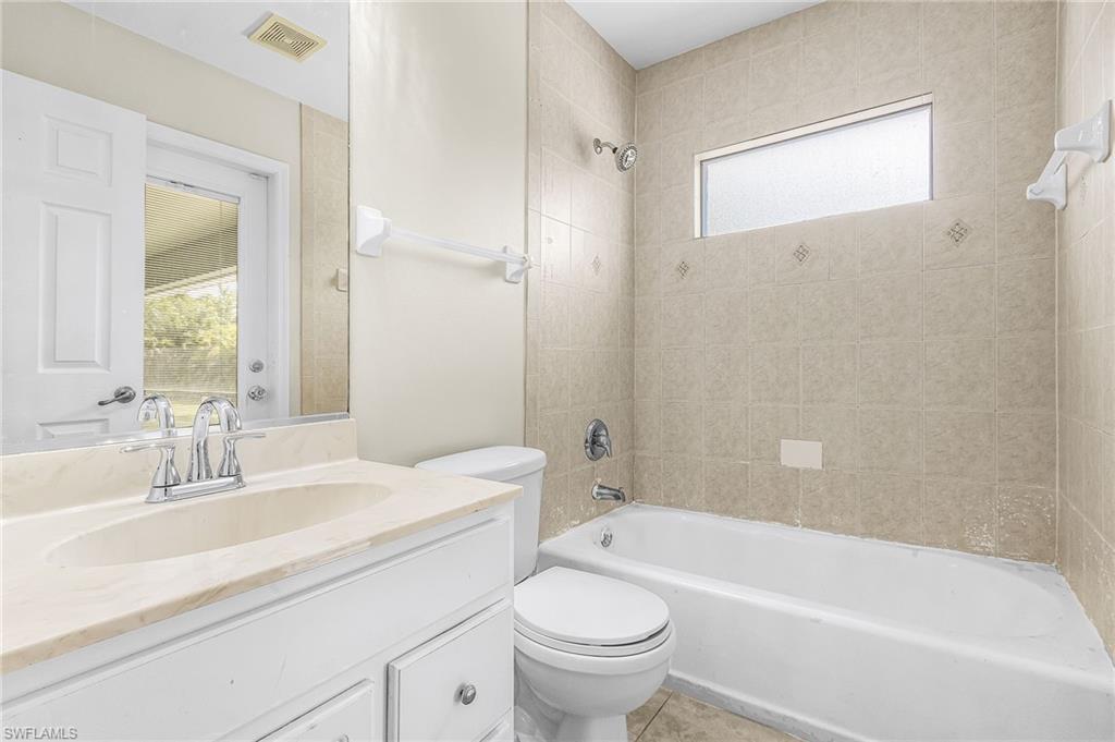 White vanity with a neutral-toned countertop and chrome faucet