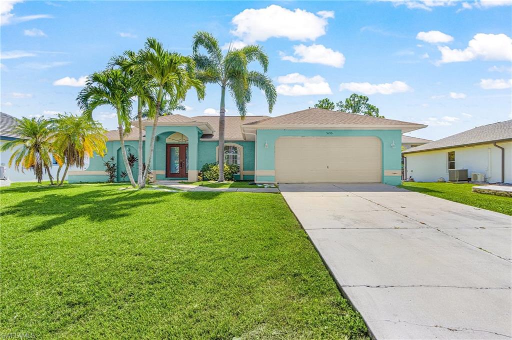 Aqua exterior with a tan roof, mature palm trees, an arched entryway, a single-car garage, and a concrete driveway