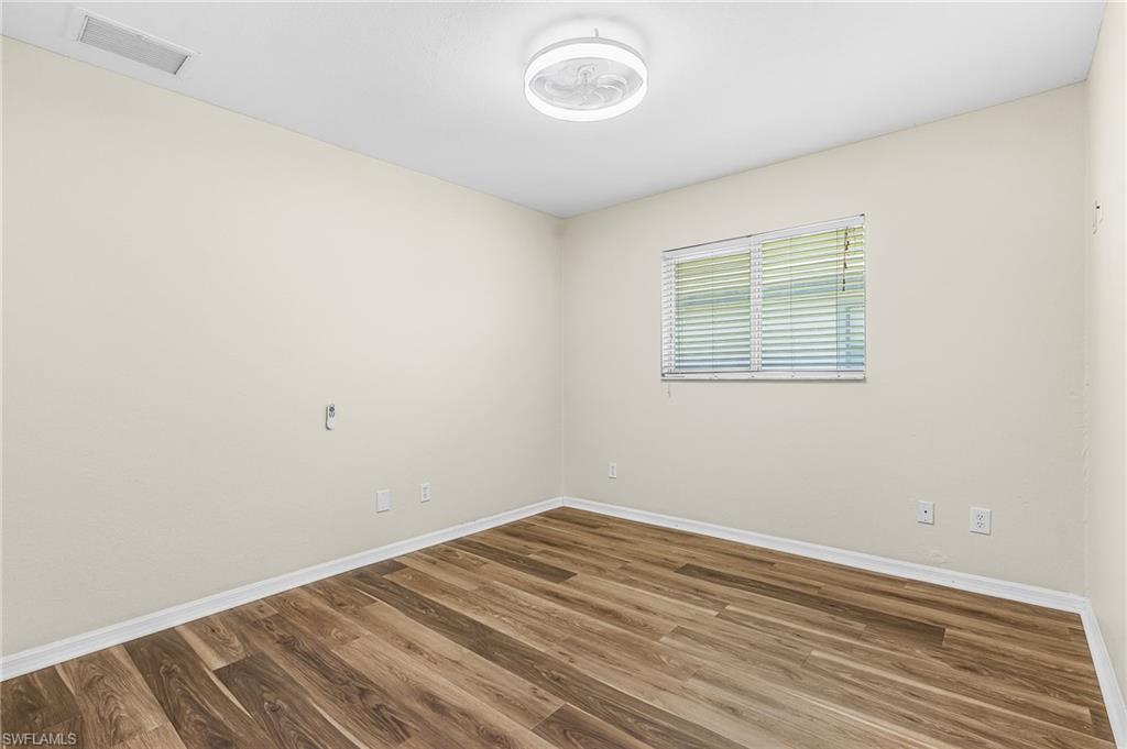Wood-finish flooring, neutral wall tones, and a window with blinds