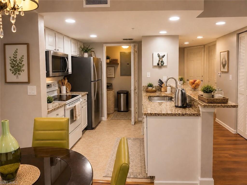 Kitchen featuring white cabinetry, stainless steel appliances, granite countertops, and recessed lighting