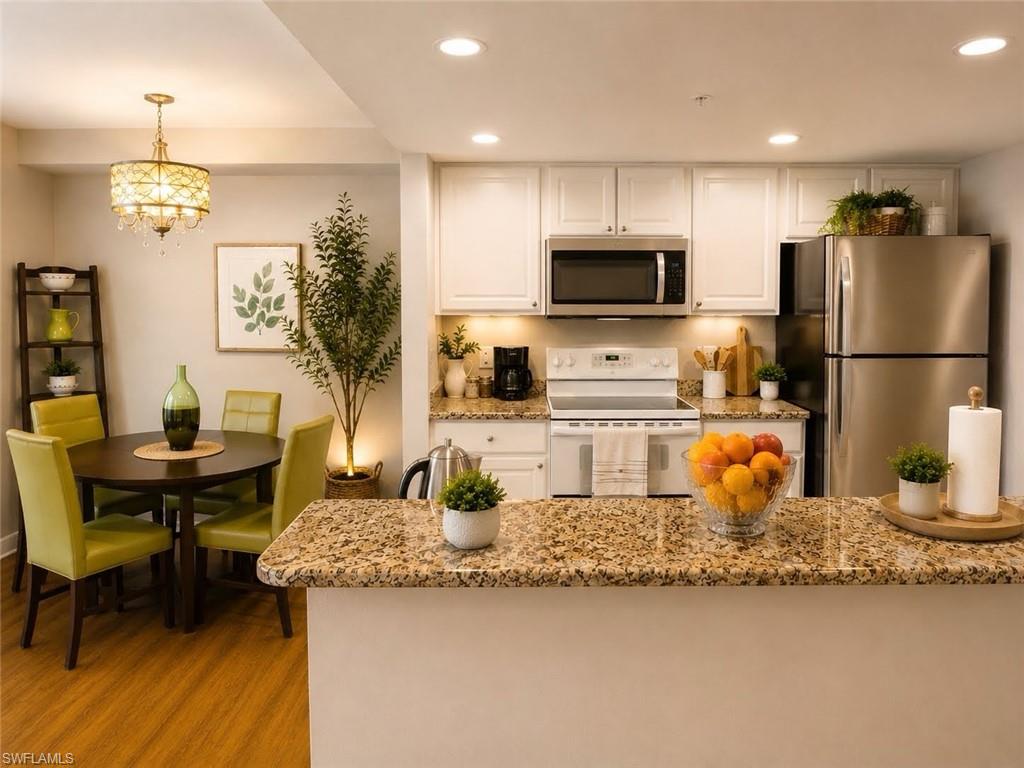 Kitchen featuring white cabinetry, stainless steel appliances, and granite countertops