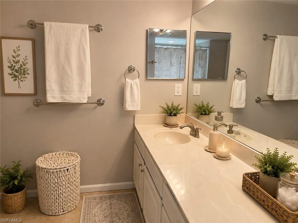 Double vanity with integrated sinks, expansive counter space, dual wall-mounted mirrors, and brushed nickel fixtures