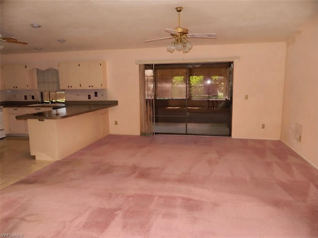 Spacious open-concept living area featuring wall-to-wall carpeting, recessed lighting, and a ceiling fan