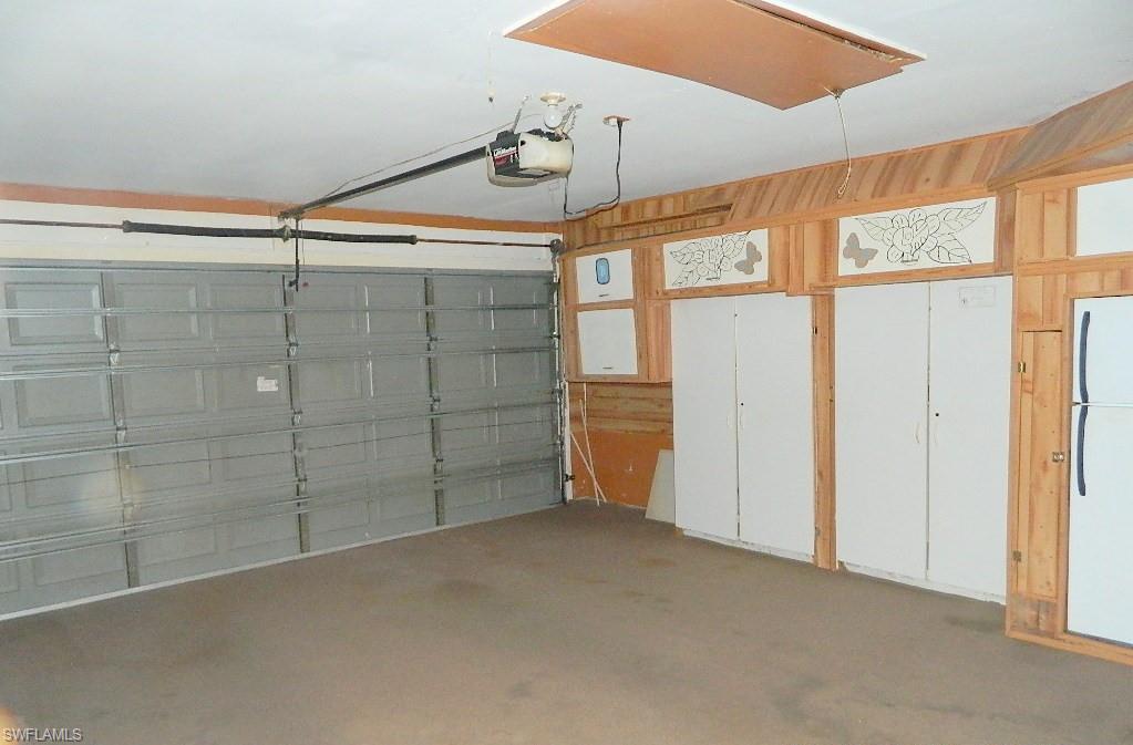 Interior garage featuring a paneled overhead door, built-in wooden cabinetry, and overhead lighting