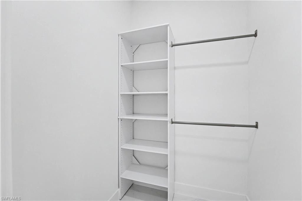Closet featuring multiple shelves with integrated support brackets and dual hanging rods, offering ample storage and organizational capacity for a range of garments and accessories