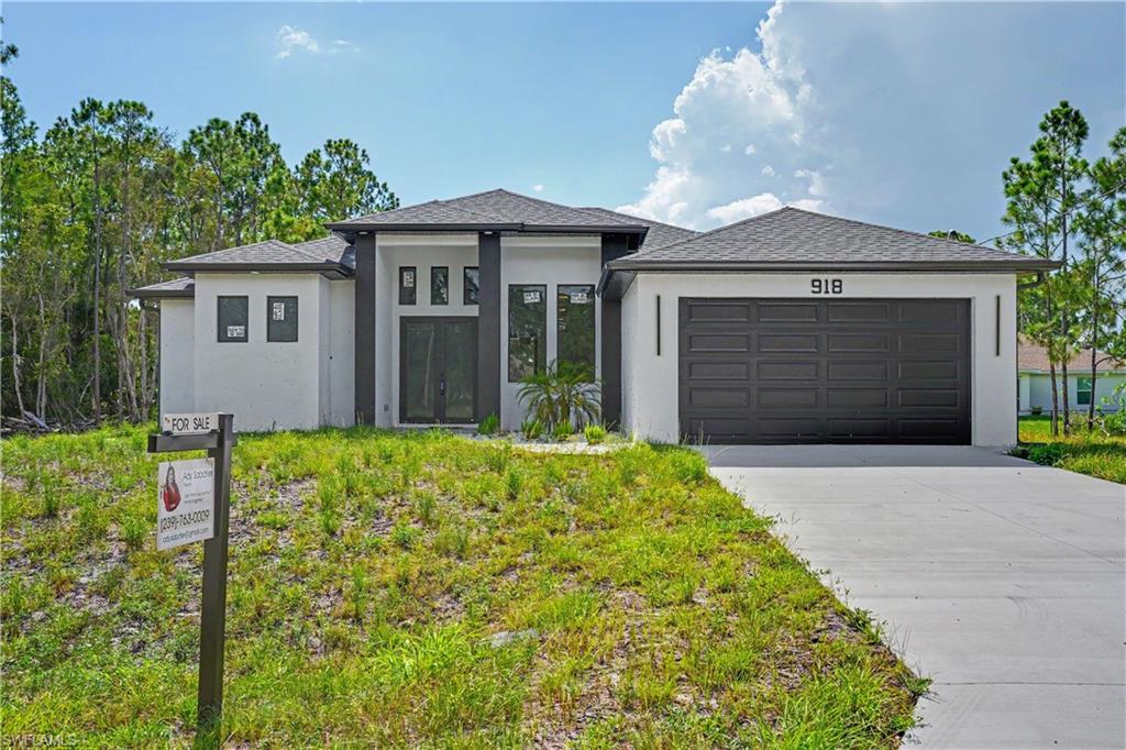Modern residence featuring a striking contemporary exterior with clean architectural lines, dark horizontal garage doors, and a welcoming entry portico