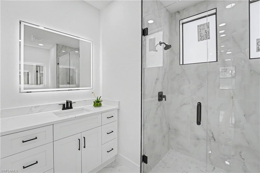 White vanity with black hardware, integrated sink, and white countertop