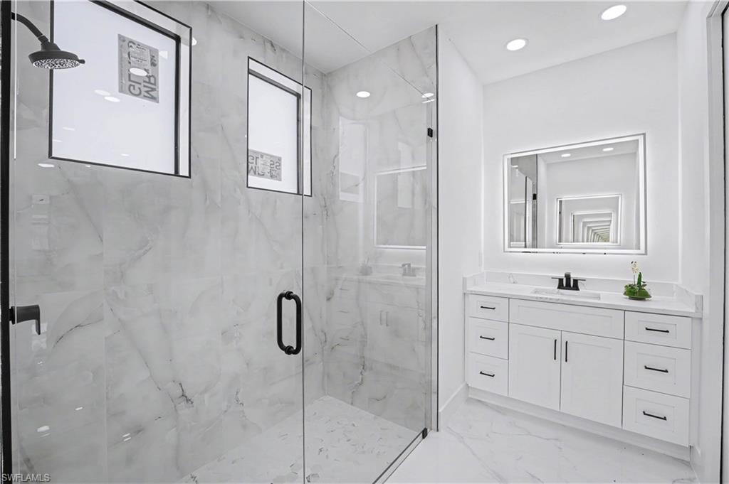 Spacious shower with glass enclosure and rainfall showerhead
