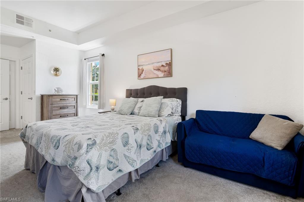 Tray ceiling with recessed lighting, double-pane window, carpet flooring, and a wood-finish dresser