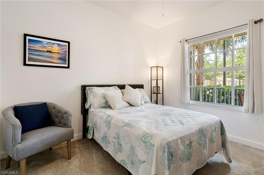 Carpeted room with a large grid-pattern window, white walls, and a recessed ceiling light fixture