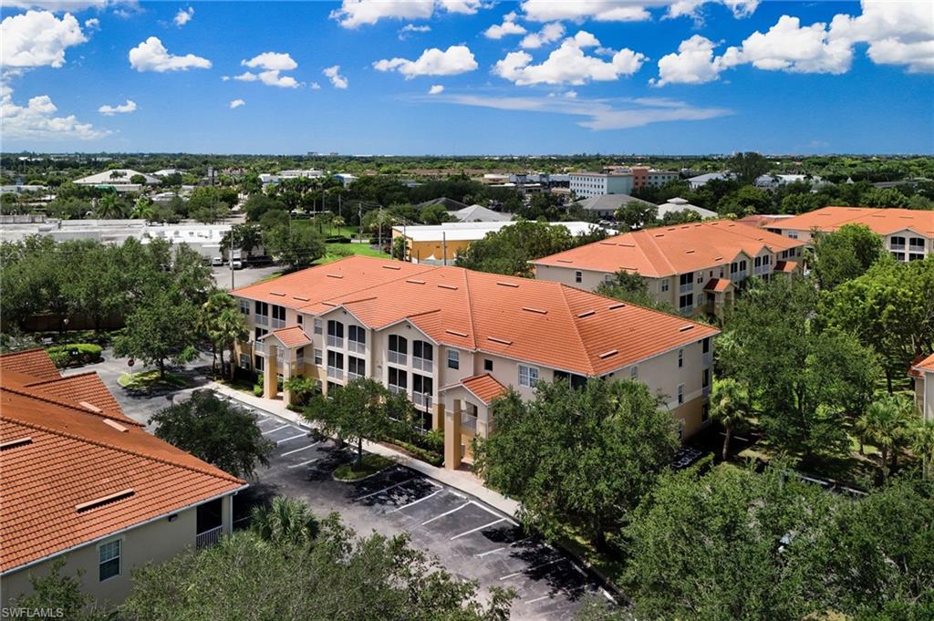 Distinctive multi-unit residential complex featuring terracotta clay tile roofing, stucco exterior walls, and mature landscaping throughout the grounds