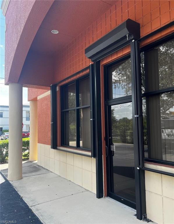 Exterior featuring a recessed ceiling light, decorative wall tiling, a window, and a glass entry door