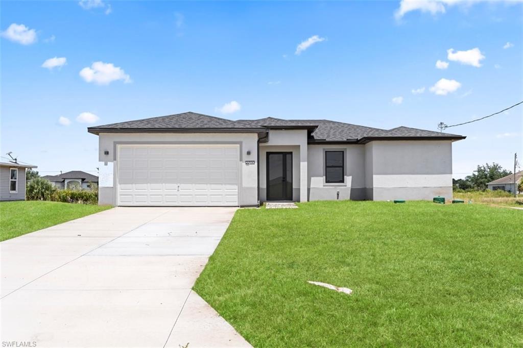 Contemporary stucco exterior with a dark shingle roof, integrated garage, concrete driveway, and front lawn