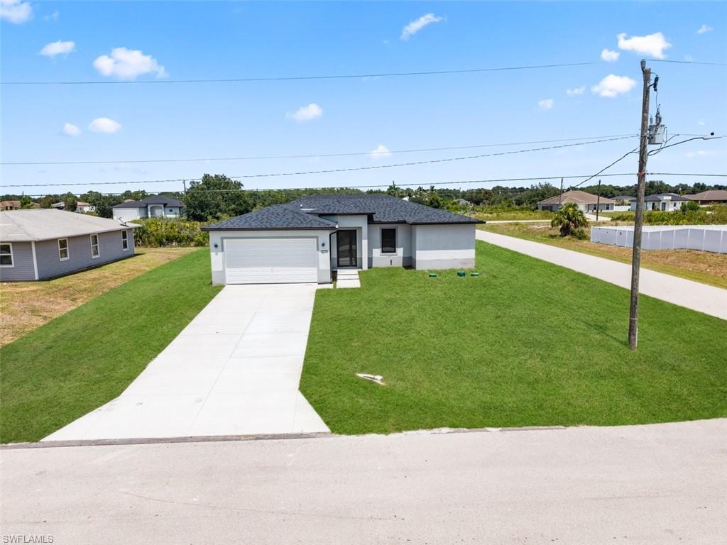 Modern exterior featuring a prominent garage, concrete driveway, and a well-maintained lawn