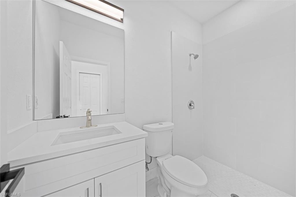 White vanity with brushed nickel faucet, integrated rectangular sink, and light-colored countertop
