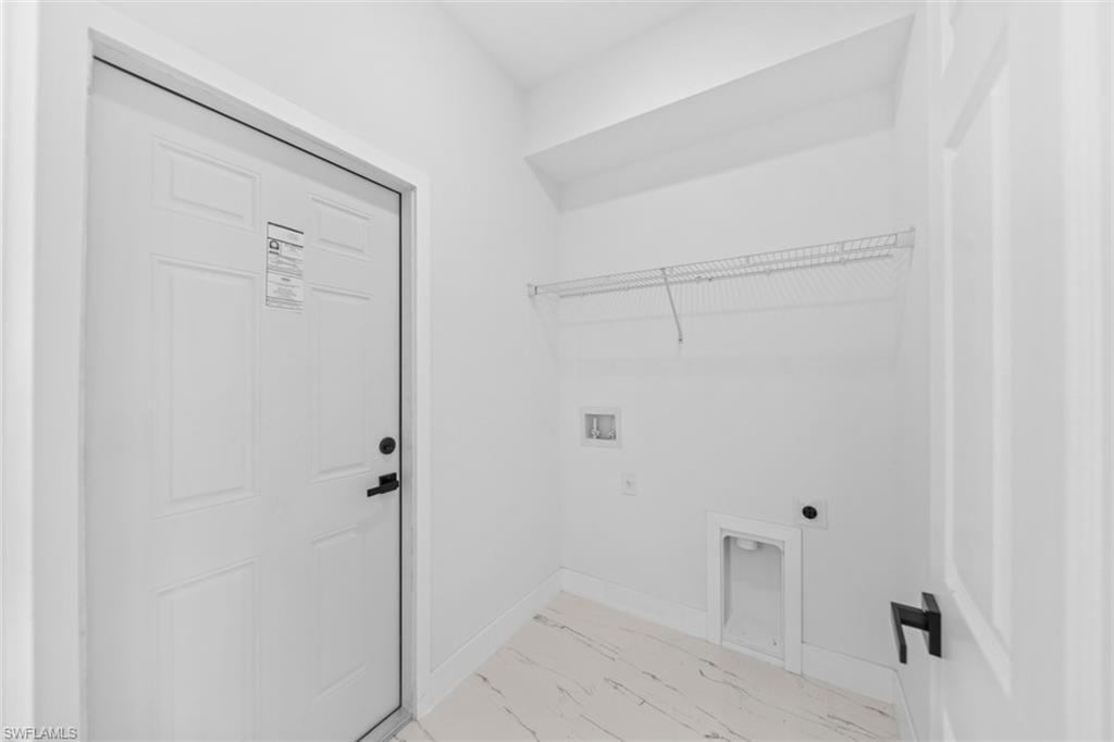 White interior door with black hardware, wire shelving, and appliance hookups
