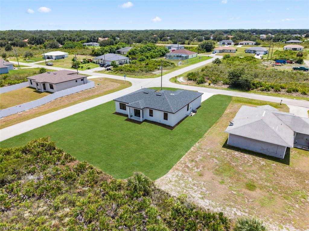 Single-story residence with a dark shingle roof, white exterior walls, and a manicured lawn