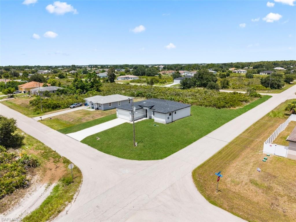 Corner lot property with a concrete driveway, attached two-car garage, and a manicured lawn