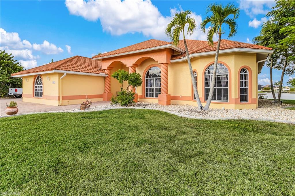 Mediterranean / spanish home featuring stucco siding, a front yard, and a tile roof