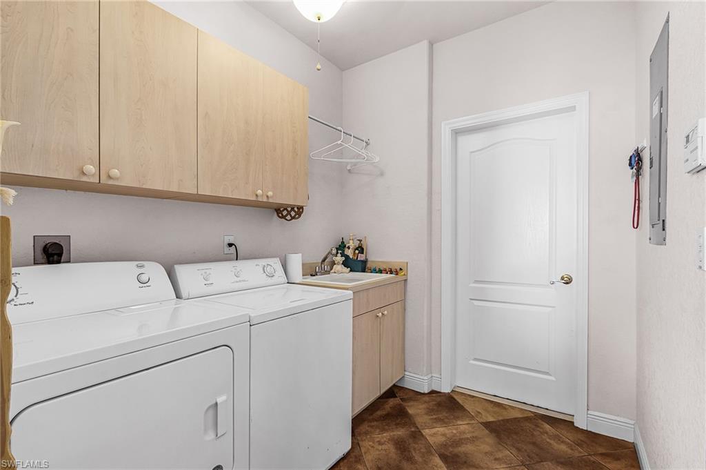 Washroom featuring cabinet space and independent washer and dryer