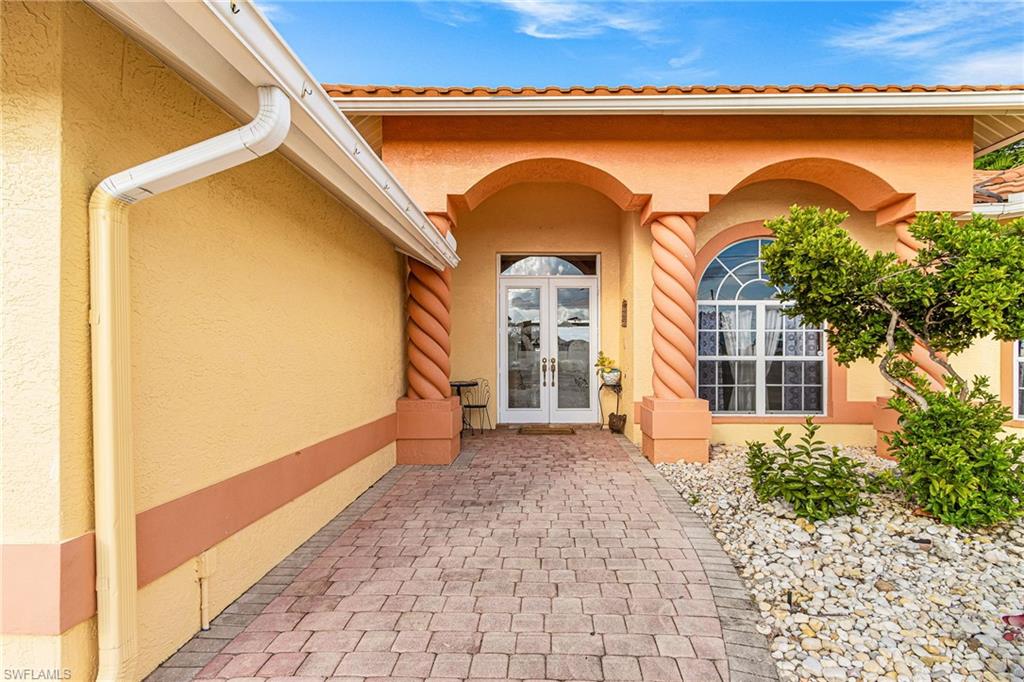 Property entrance featuring stucco siding and french doors