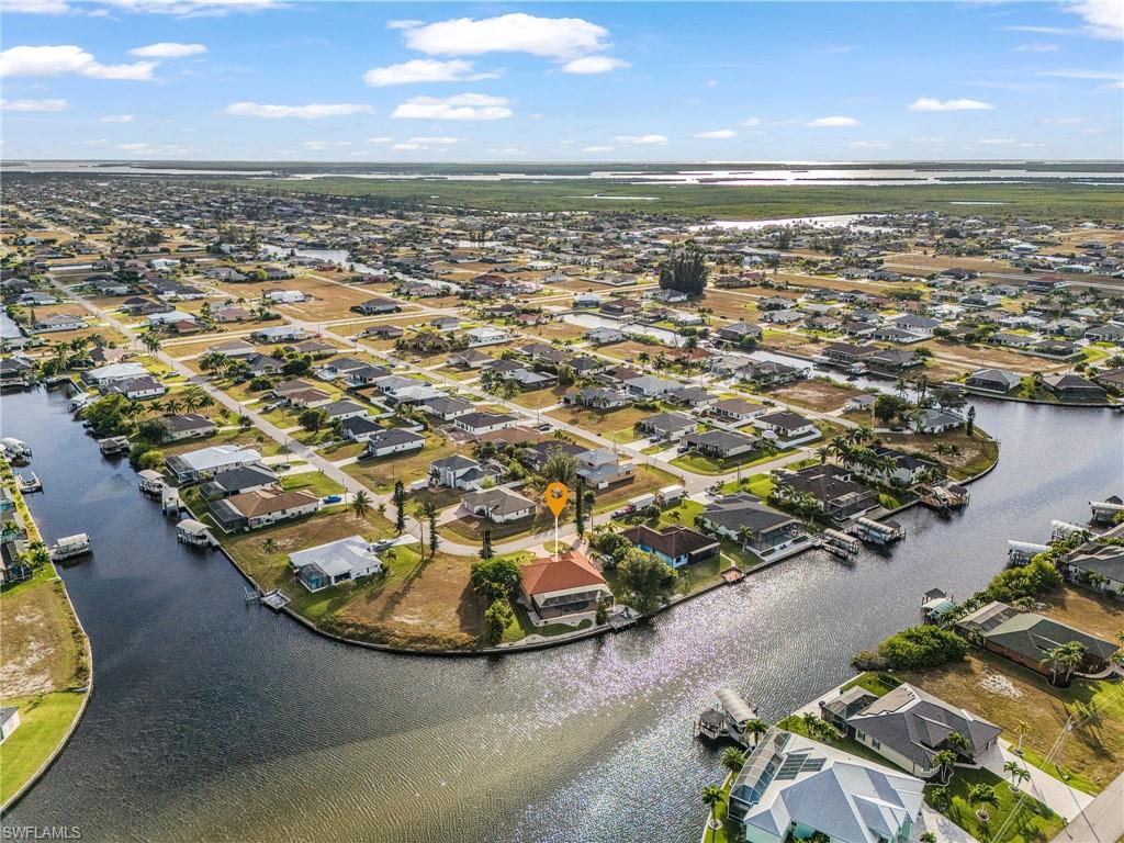 Aerial view of property and surrounding area with a large body of water and nearby suburban area