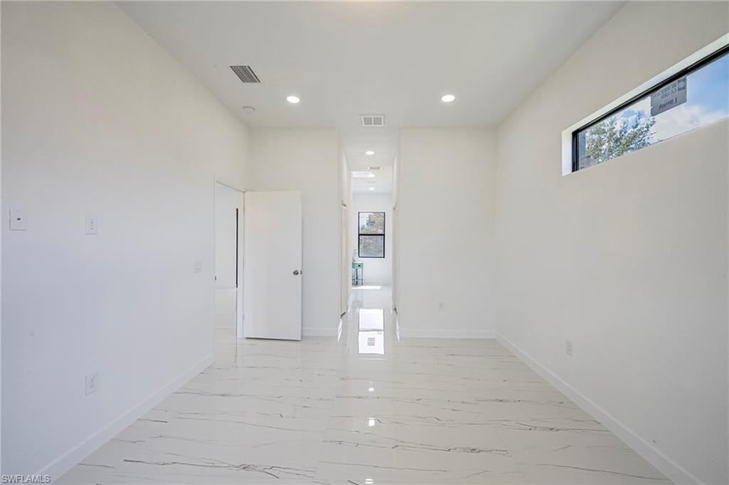 Empty room with recessed lighting and light marble finish flooring