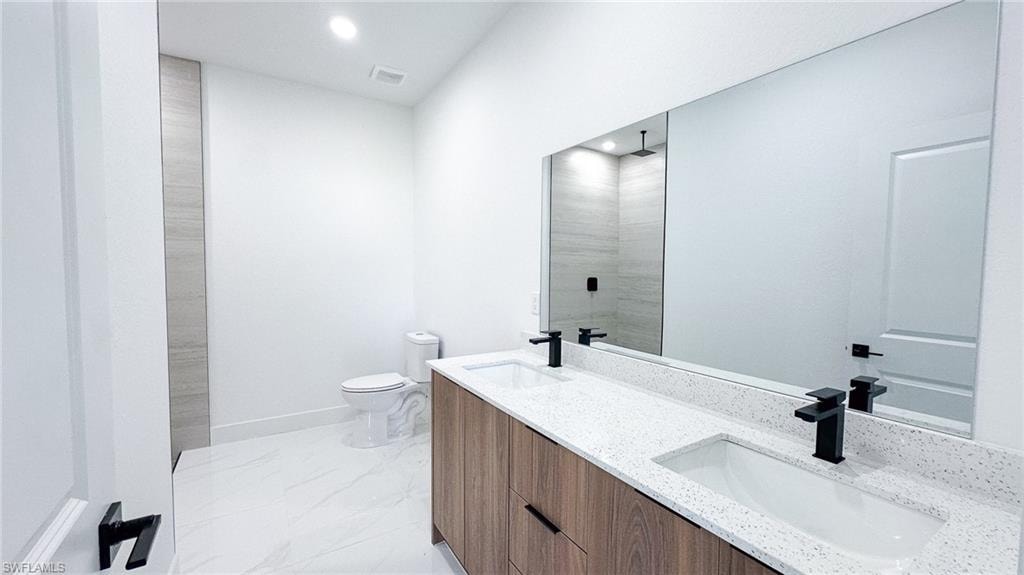 Dual vanity with wood-finish cabinetry, white countertop, and matte black fixtures