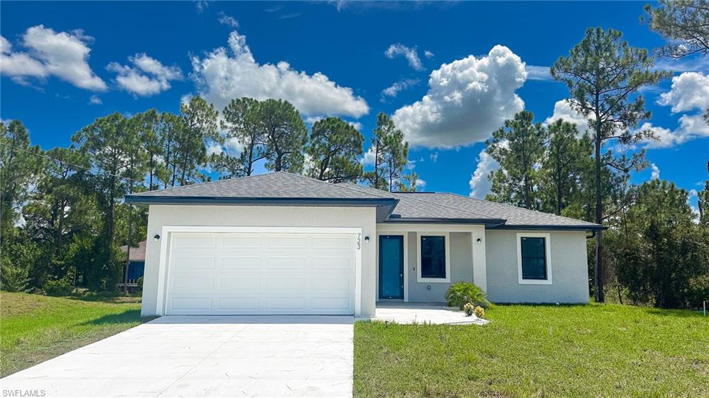 Modern single-story residence with a concrete driveway, two-car garage, and a blue entry door