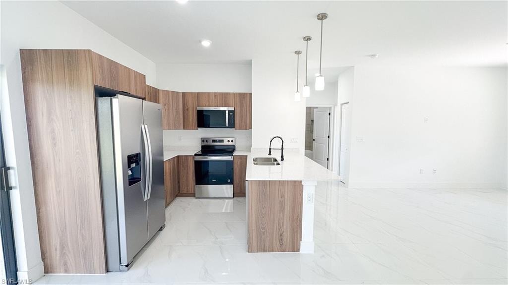 Modern kitchen featuring wood-finish cabinetry, stainless steel appliances, white countertops, and white tile flooring