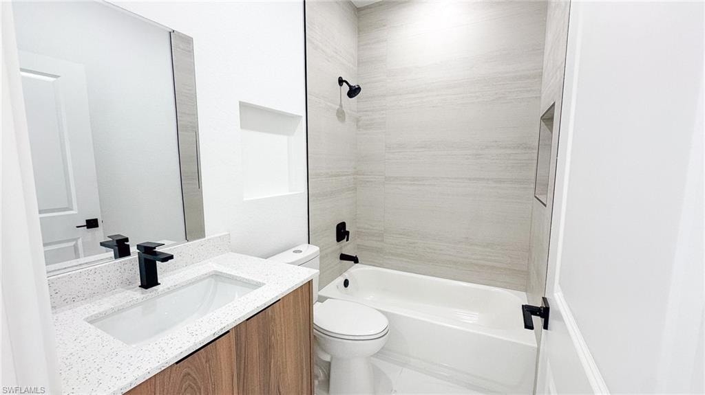 Modern bathroom featuring a floating wood-finish vanity with a rectangular white sink, quartz countertop, and matte black hardware