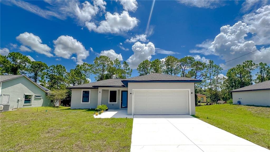 Modern single-story residence featuring a clean contemporary exterior with neutral siding, prominent two-car garage with white paneled door, and a wide concrete driveway