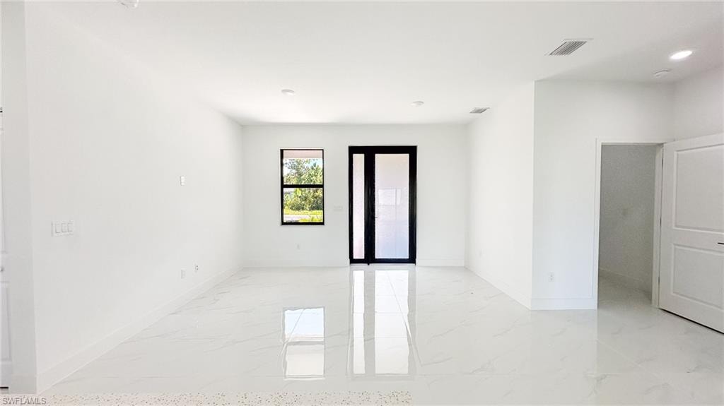 Bright, open living space featuring polished light-finish flooring, recessed ceiling lighting, and clean white walls