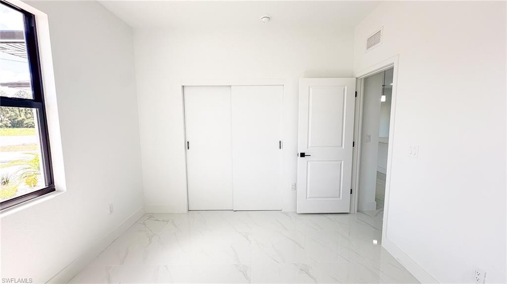 White wall finishes, recessed lighting, and large format tile flooring