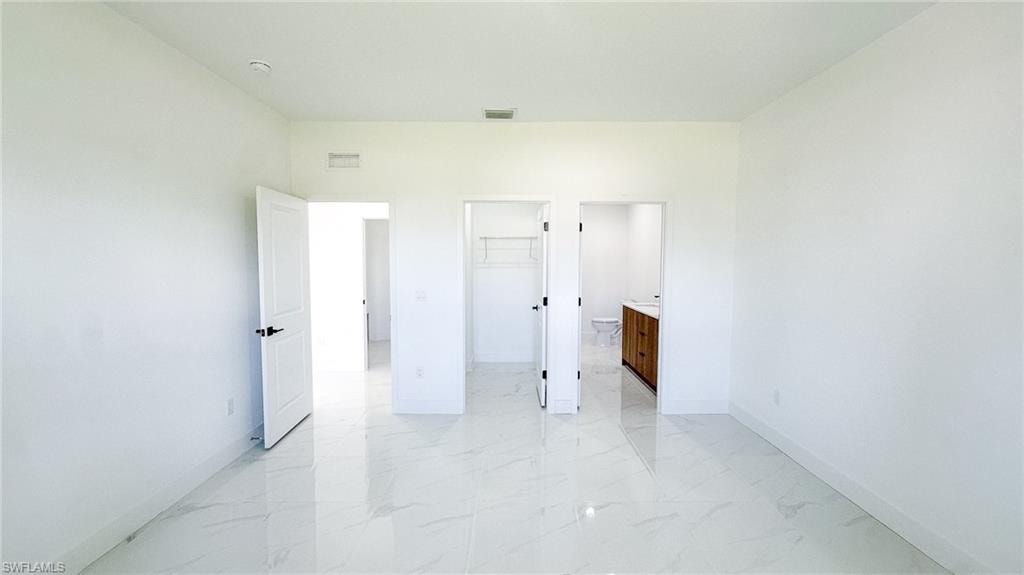 White tile flooring, white walls, and white doors with matte black hardware