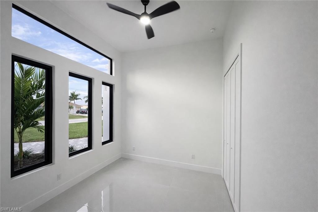 Unfurnished room with a ceiling fan and baseboards