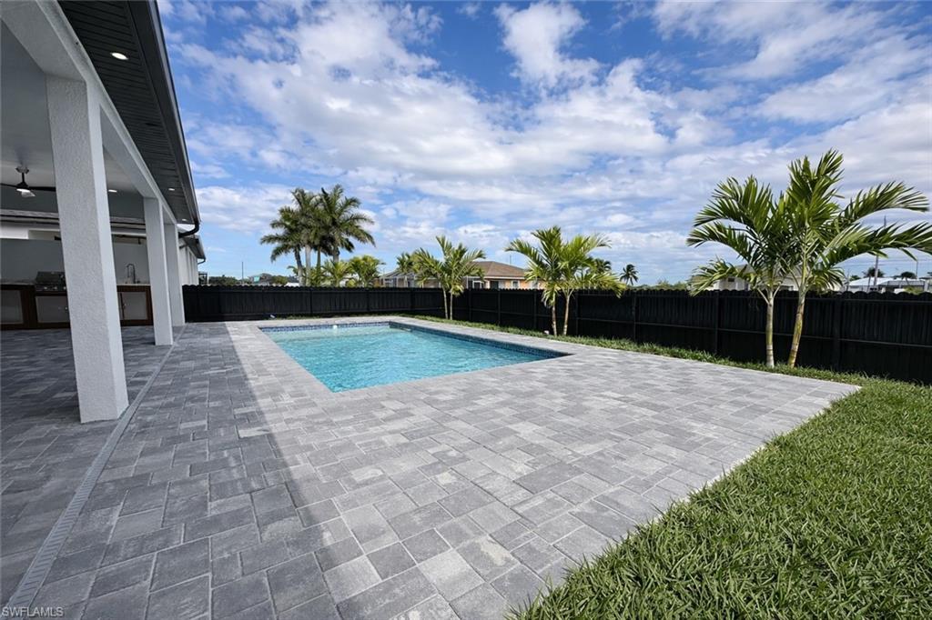 View of pool with a fenced backyard and patio surround