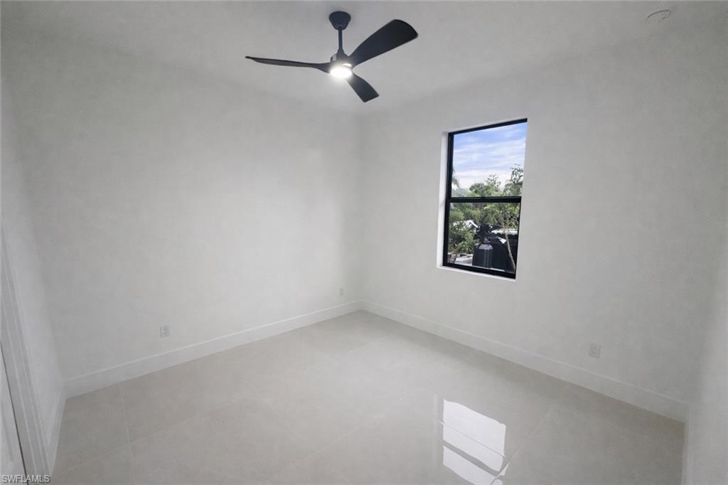 Spare room featuring ceiling fan and light tile patterned floors