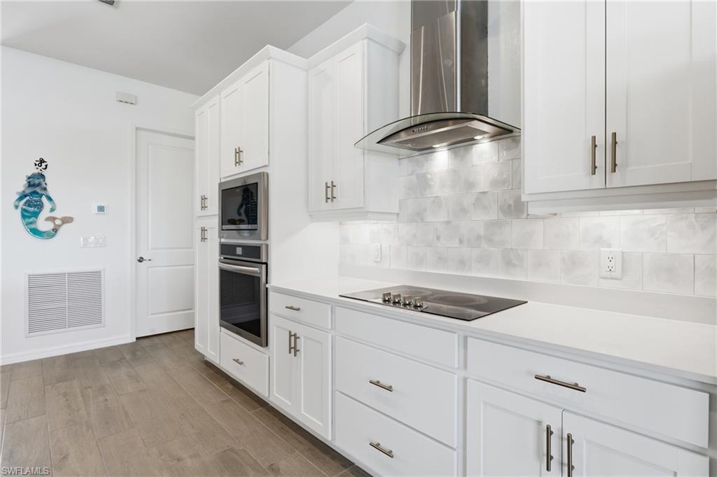 Gourmet kitchen with an expansive island, white shaker cabinetry, and Frigidaire Gallery appliances