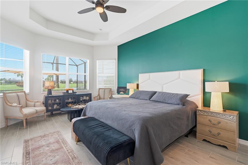 Primary bedroom with tray ceiling, door to lanai and bay window