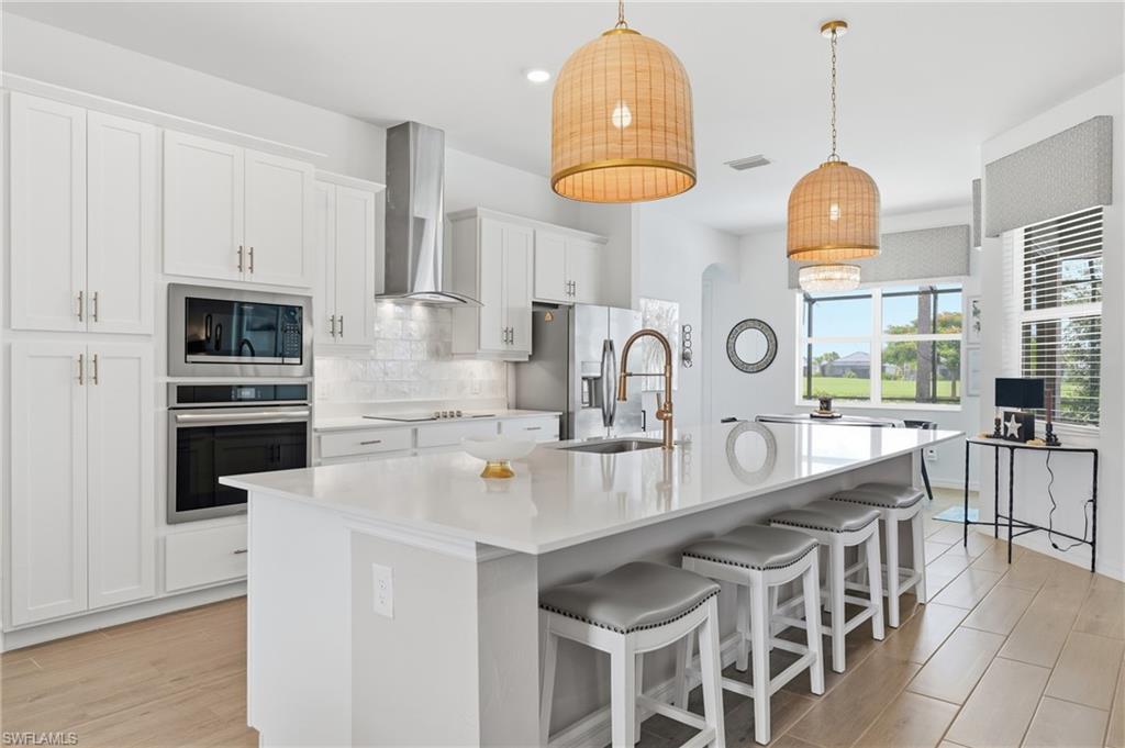 Gourmet kitchen with an expansive island, white shaker cabinetry, and Frigidaire Gallery appliances