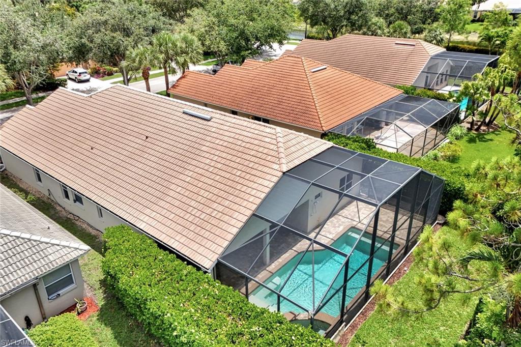 Screened-in pool area featuring an in-ground swimming pool and surrounding paved patio