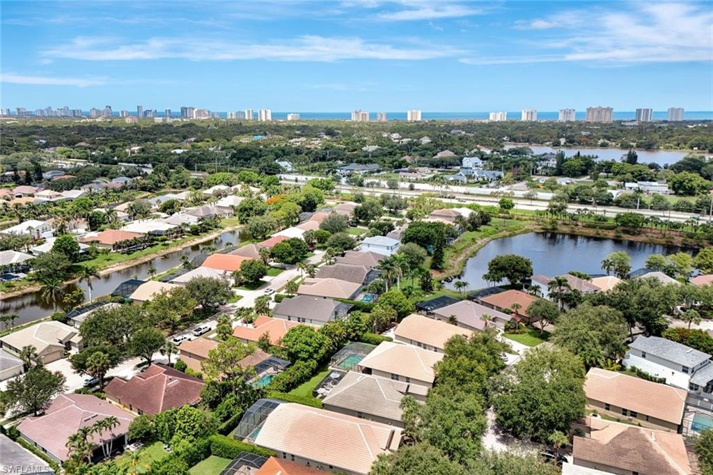 Residential community with multiple waterways, mature landscaping, and distant high-rise buildings