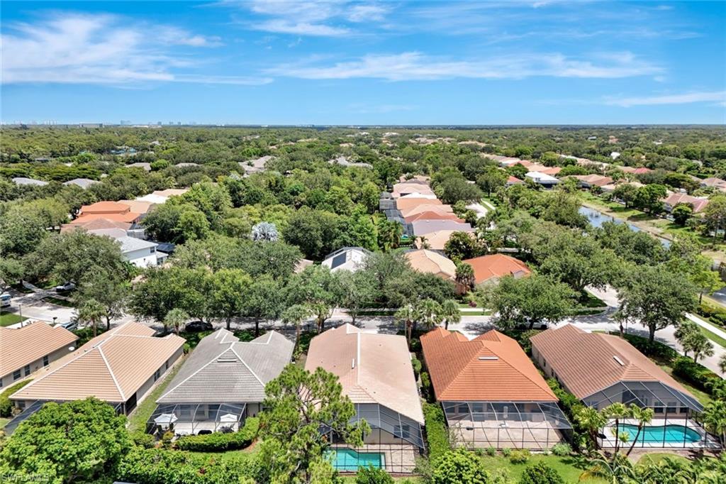 Expansive residential area with numerous properties, mature trees, and several homes featuring screened pools
